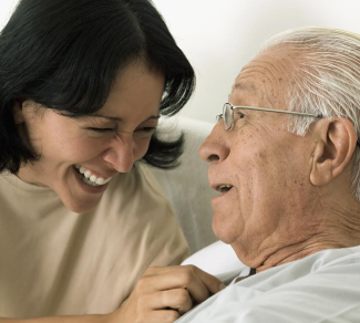 Woman caregiver smiling at elderly gentleman