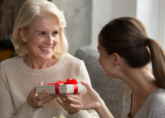 Grandchild giving grandmother a holiday gift