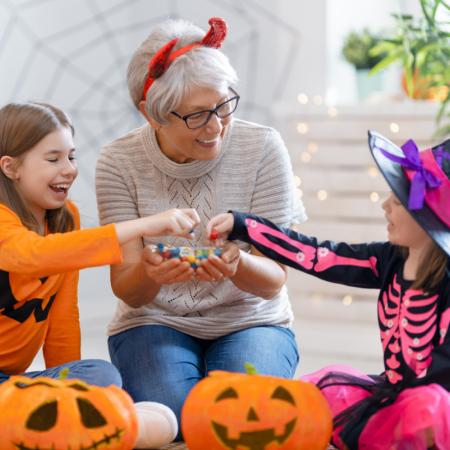 Senior and grandchildren eating candy on Halloween